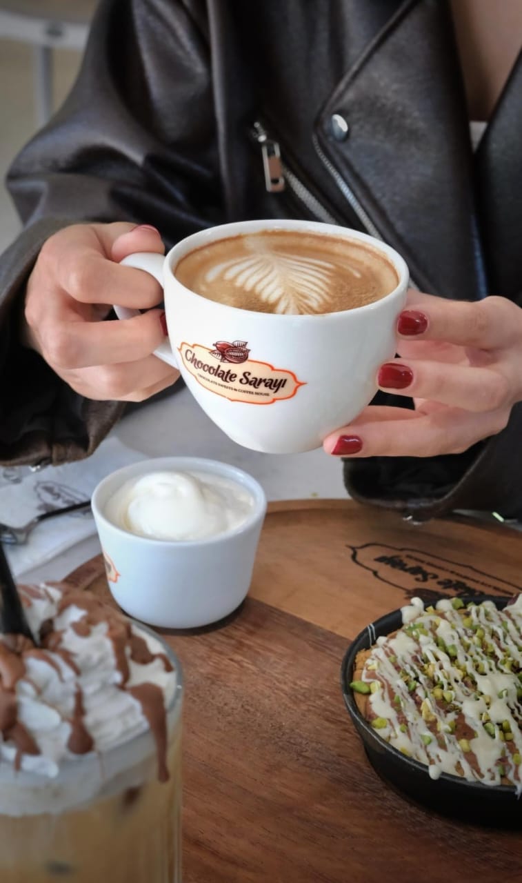 Cappuccino with latte art in a branded cup